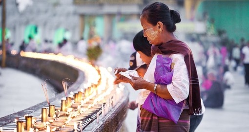 Buddhist devotees lighting candles during full moon festival