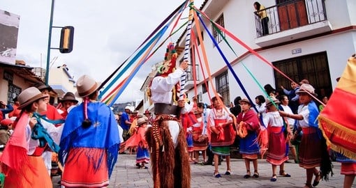 Indigenous group dancing around pole in traditional costume