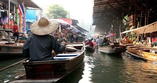 Learn about traditional culture and practices while floating on wooden boats in the floating market on you Thailand Vacation