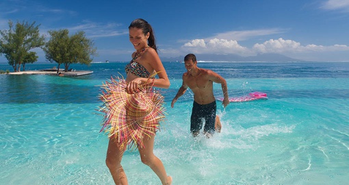 Couple jumping in the water of Tahiti