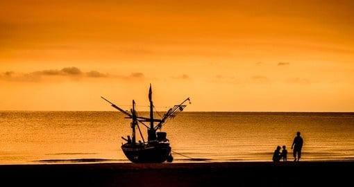 A fishing boat and family at sunset in Hua Hin