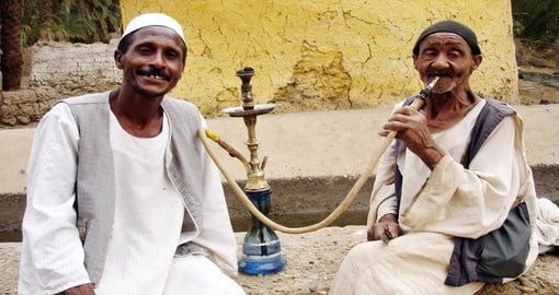 Men smoke from a shisha pipe