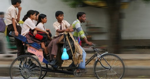 An Indian family riding a cycle rickshaw