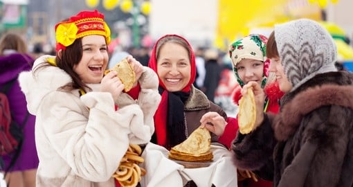 Women eating pancakes during Shrovetide in Russia