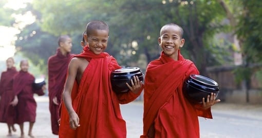 Young Buddhist monks smiling on their morning alms walk