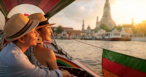 Couple on river cruise with Wat Arun in background