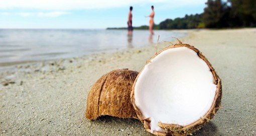 Opened coconut on a sandy beach