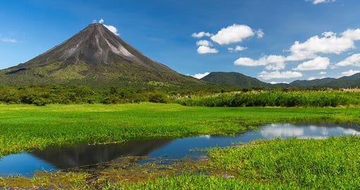 Admire the idyllic image created by the Arenal volcano jetting up into the sky