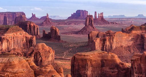Monument Valley is a cluster of vast sandstone buttes, the largest reaching 1,000 ft (300 m) above the valley floor