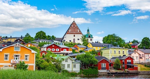 Walk along the waterside in Porvoo, known for their vibrant wooden warehouses in Old Town
