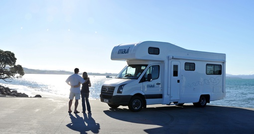 Couple standing with a motor home/RV