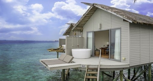 Sit outside of you water Villa at the Centara Ras Fushi Resort during your Trip to Maldives.
