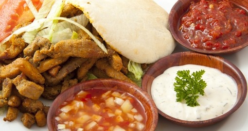 Pita filled with shoarma on a plate with sauce