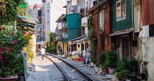 Witness close quarters in the Old Quarter of Hanoi, featuring a community built tightly around running train tracks
