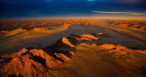 Admire the pink and orange tones of the sand dunes covering the Namib desert in Sossusvlei