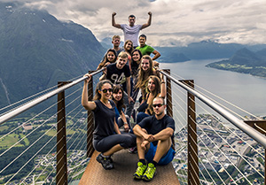 Group of travelers stop to pose on a suspension bridge